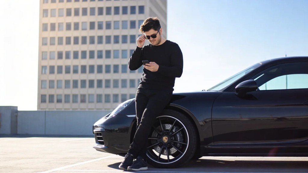 Professional photo of Arian Azmoudeh, CEO and co-founder, outdoors beside a luxury car